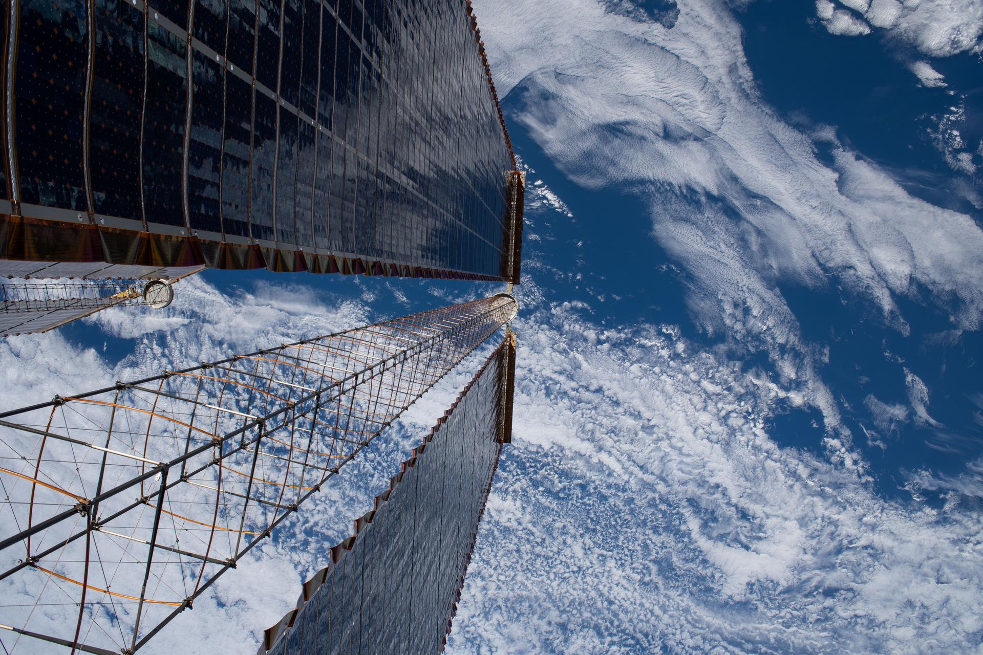 A view peering down a pair of the International Space Station's roll-out solar arrays