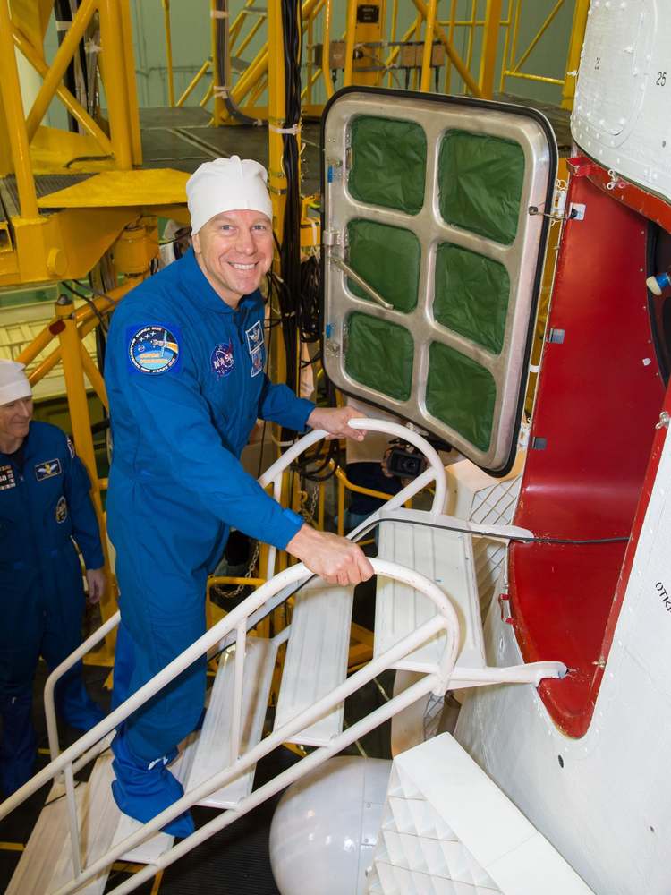 In the Integration Facility at the Baikonur Cosmodrome in Kazakhstan, Expedition 46-47 crewmember Tim Kopra of NASA flashes a smile before entering his Soyuz spacecraft Dec. 10 during a final fit check and inspection. Kopra, Tim Peake of the European Space Agency and Yuri Malenchenko of the Russian Federal Space Agency (Roscosmos) will launch Dec. 15 on the Soyuz TMA-19M spacecraft for a six-month mission on the International Space Station...NASA/Victor Zelentsov.